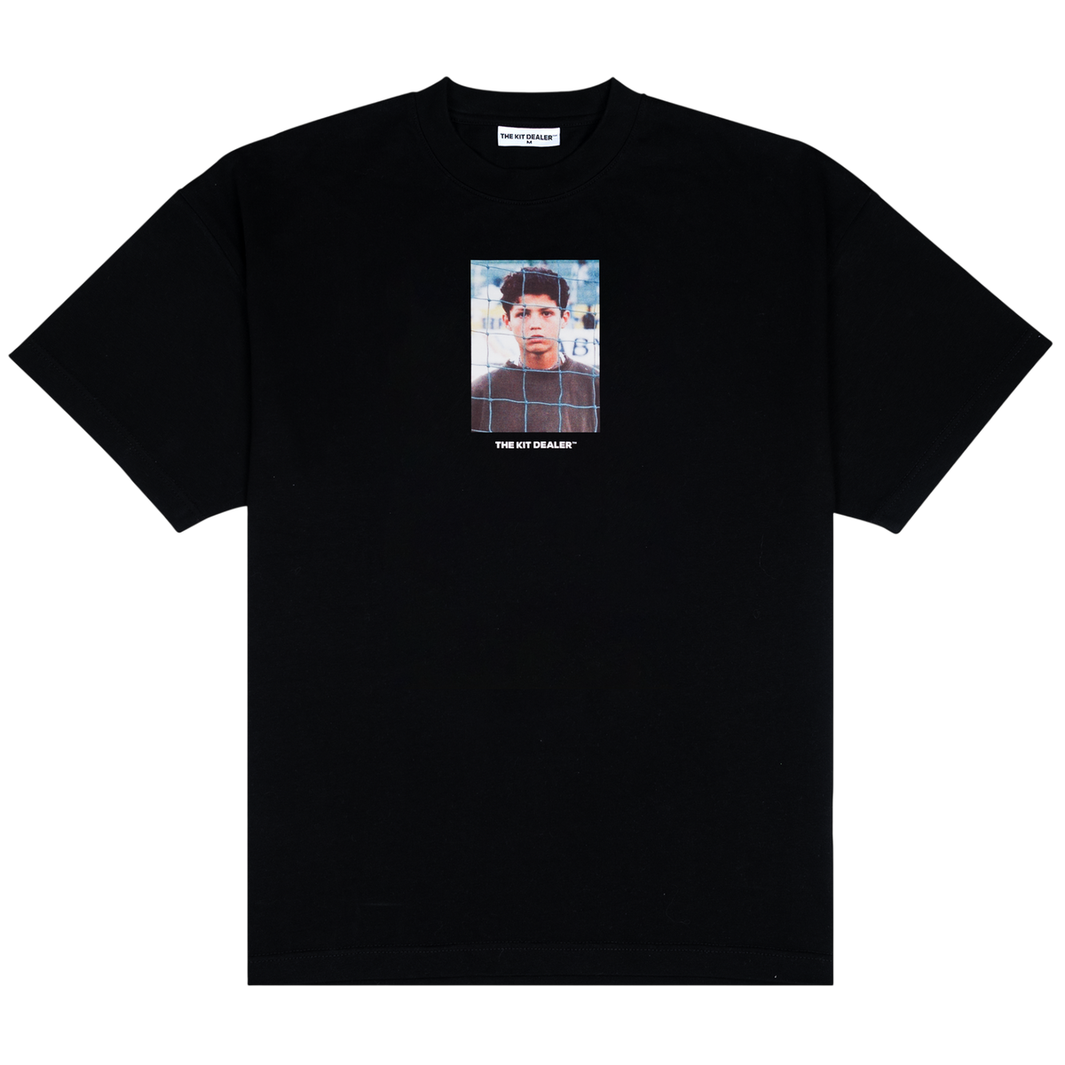 Funchal Tee, front: black heavyweight cotton tee printed with a photo of a young Cristiano Ronaldo behind a goal net, THE KIT DEALER wordmark below